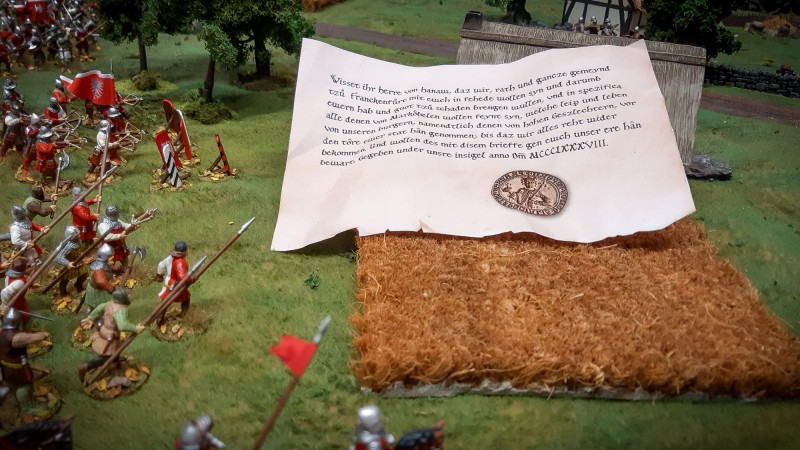 Das Dokument, mit dem die Frankfurter die rechtmäßige Fehde erklärt hatten:<br /><br />Wisset ihr Herre von Hanaw, daz wir, rath und gancze gemeynd tzů Franckenfůrt mit ewch in fehede wollen syn und darumb ewern hab und guot tzů schaden brengen wullen, vnd in spezifica alle denen von Markoͤbelen wollen feynt syn, welche leip und leben von unseren burgern, namendtlich denen von hohen Geszlechtern, vor den tôre ewer stat hân genommen; bis daz wir alles reht wider bekommen. Und wollen des mit disem brieffe gen ewch unser ere hân bewart. Gegeben under unsre insigel anno Dm̅ MCCCLXXXVIII (Siegel)